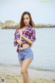 A woman standing on a beach next to the ocean.