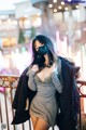 A woman wearing a face mask standing on a bridge.