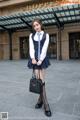 A woman in a school uniform is posing for a picture.